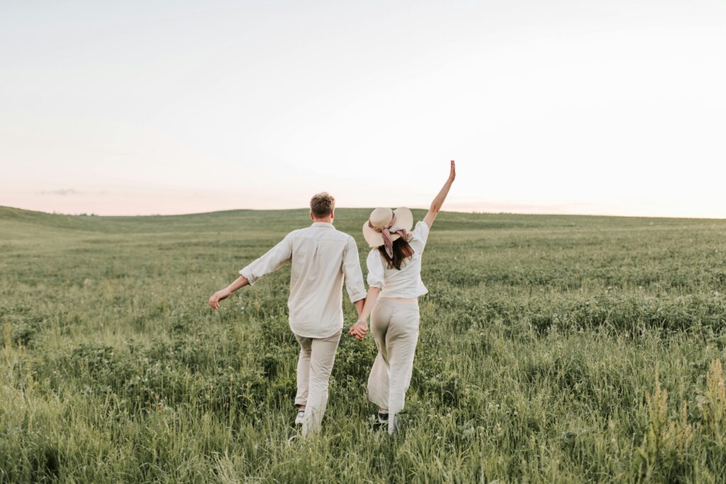 Paar beim Spaziergang auf einer grünen Wiese, ideal für ein entspanntes Sextreff in der Natur